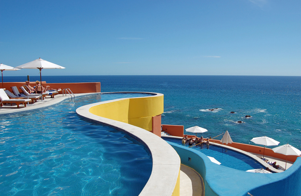 A swimming pool on a balcony overlooking the ocean.