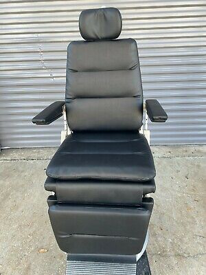 Black reclining chair with padded armrests.
