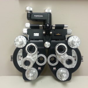 A pair of Topcon VT 10 - (minus) cyl Phoroptor eyeglasses mounted on a wall.